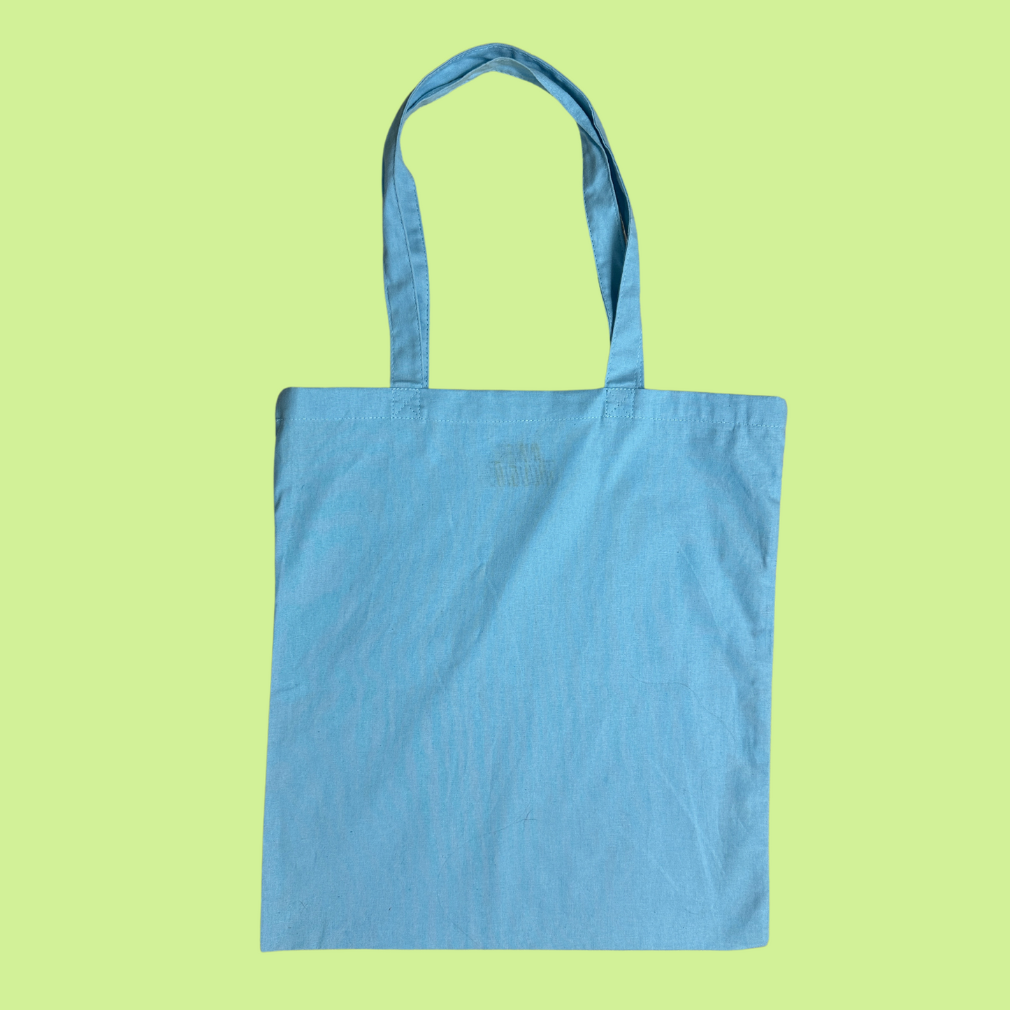 Light Blue Lightweight Tote Bag with matching fabric handles. Back of the tote bag is blank. Not ideal for heavy things like books or laptop, but perfect for a farmer's market or everyday essentials.