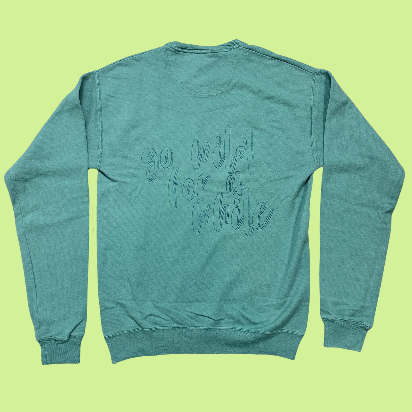 cyrpus green crewneck sweatshirt with "go wild for a while" subtly printed on the back in the same color as the front in a script font