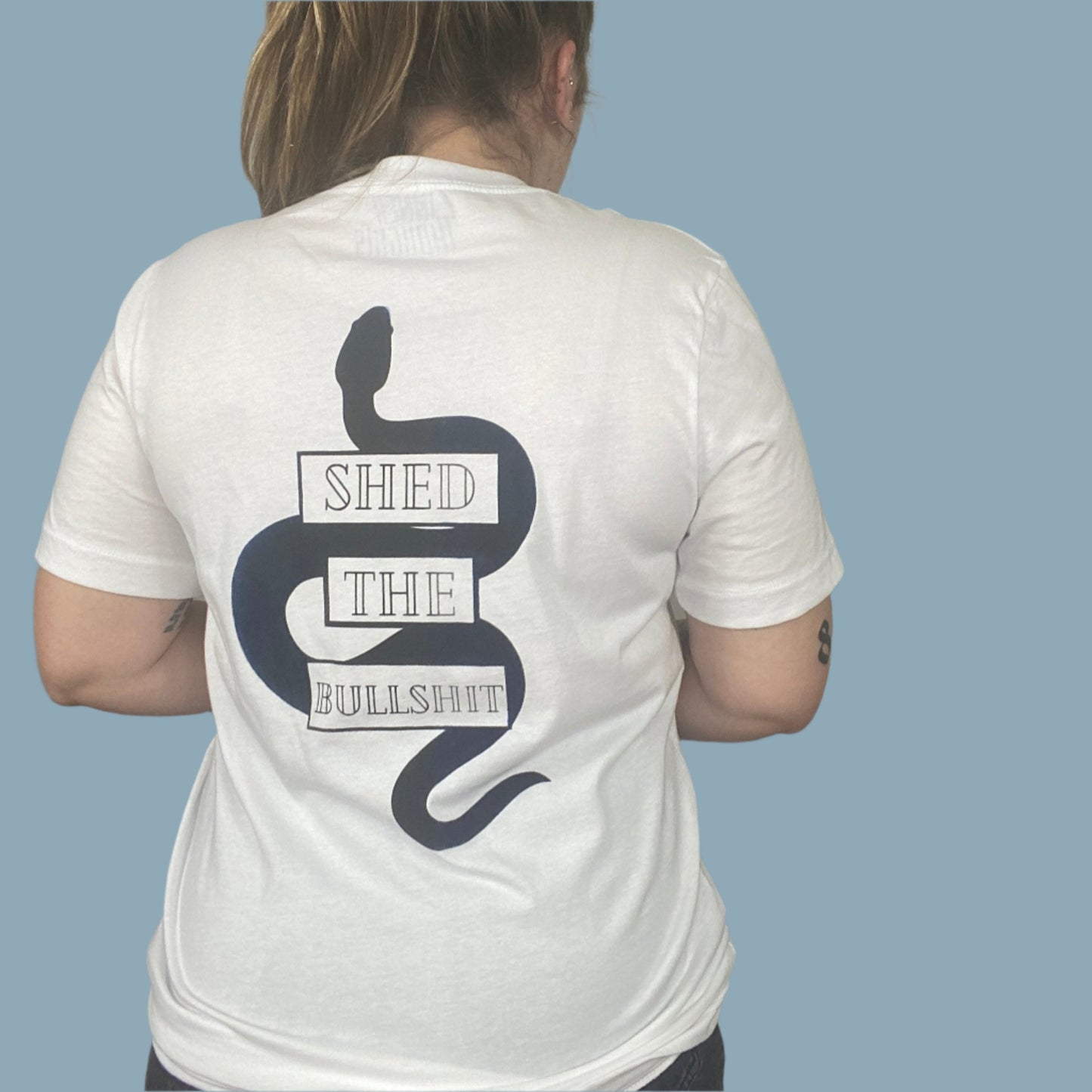 White shirt with the Shed The Bullshit design with blue areas that look faded in and out