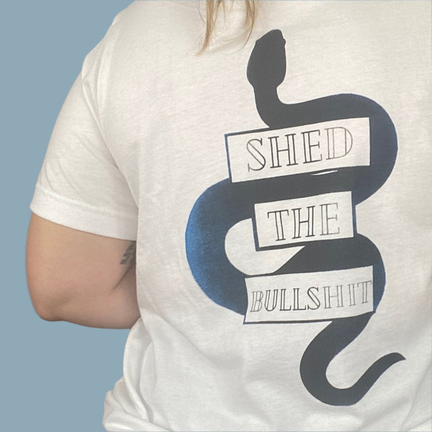 White shirt with the Shed The Bullshit design with blue areas that look faded in and out