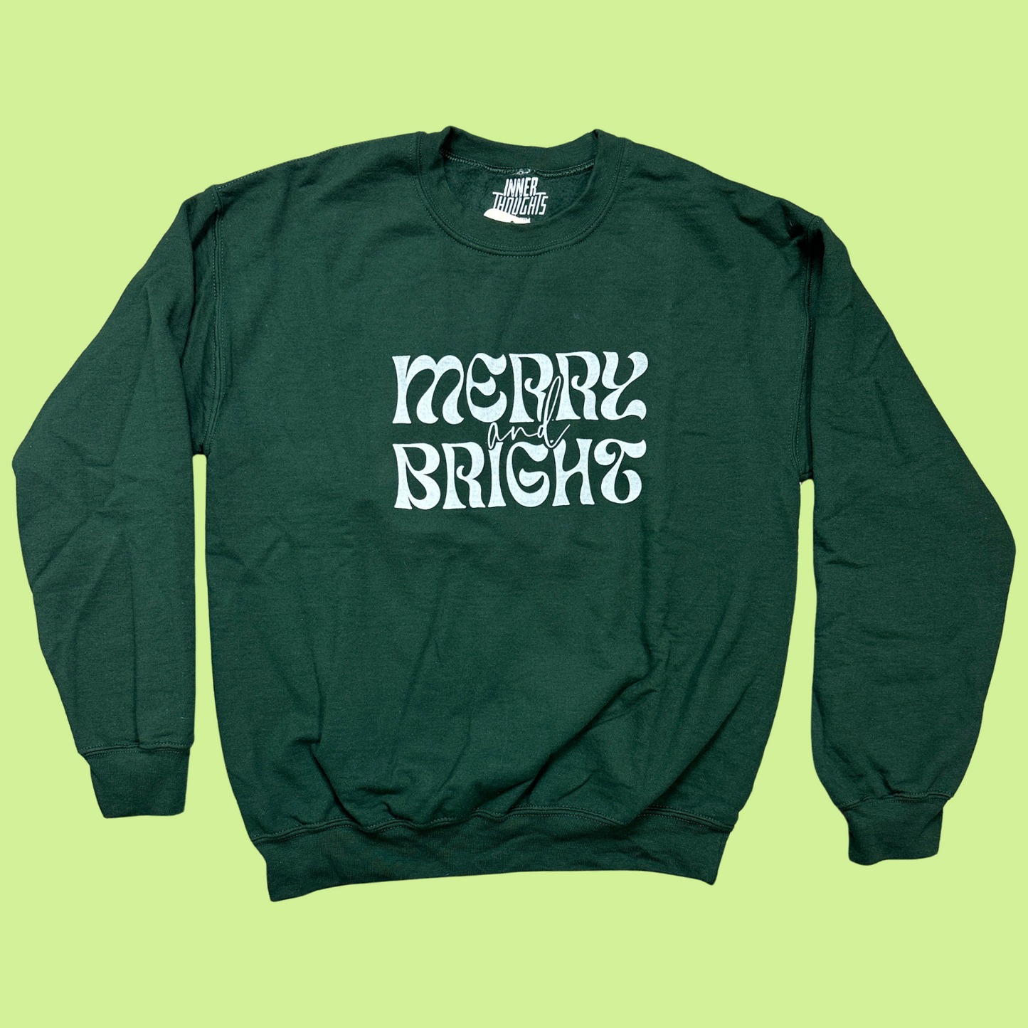 Dark Green Crewneck Sweatshirt with "merry and bright" printed on the front in white