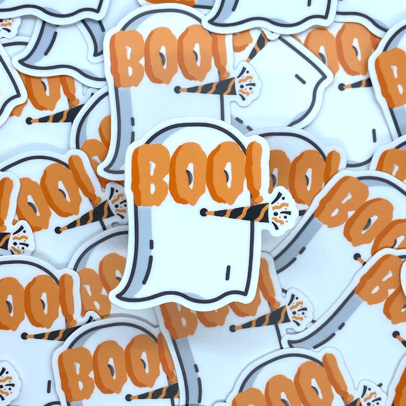 Ghost Party Sticker: A cartoon ghost with the word BOO! in orange across the face as glasses like new year's glasses and a black and orange party blower