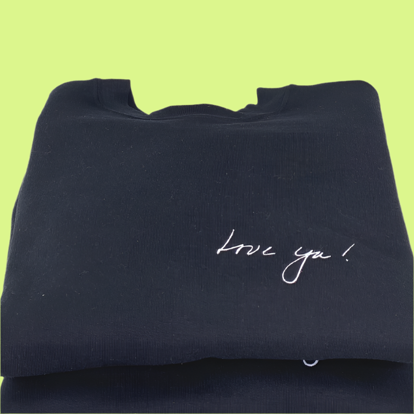 Black Crewneck Sweatshirt with Love Ya! on the right front pocket area in white; two stacked on top of each other