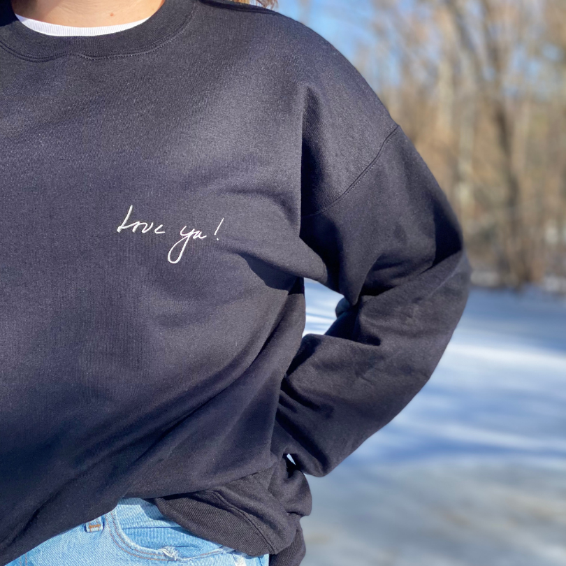 Black Crewneck Sweatshirt with Love Ya! on the right front pocket area in white