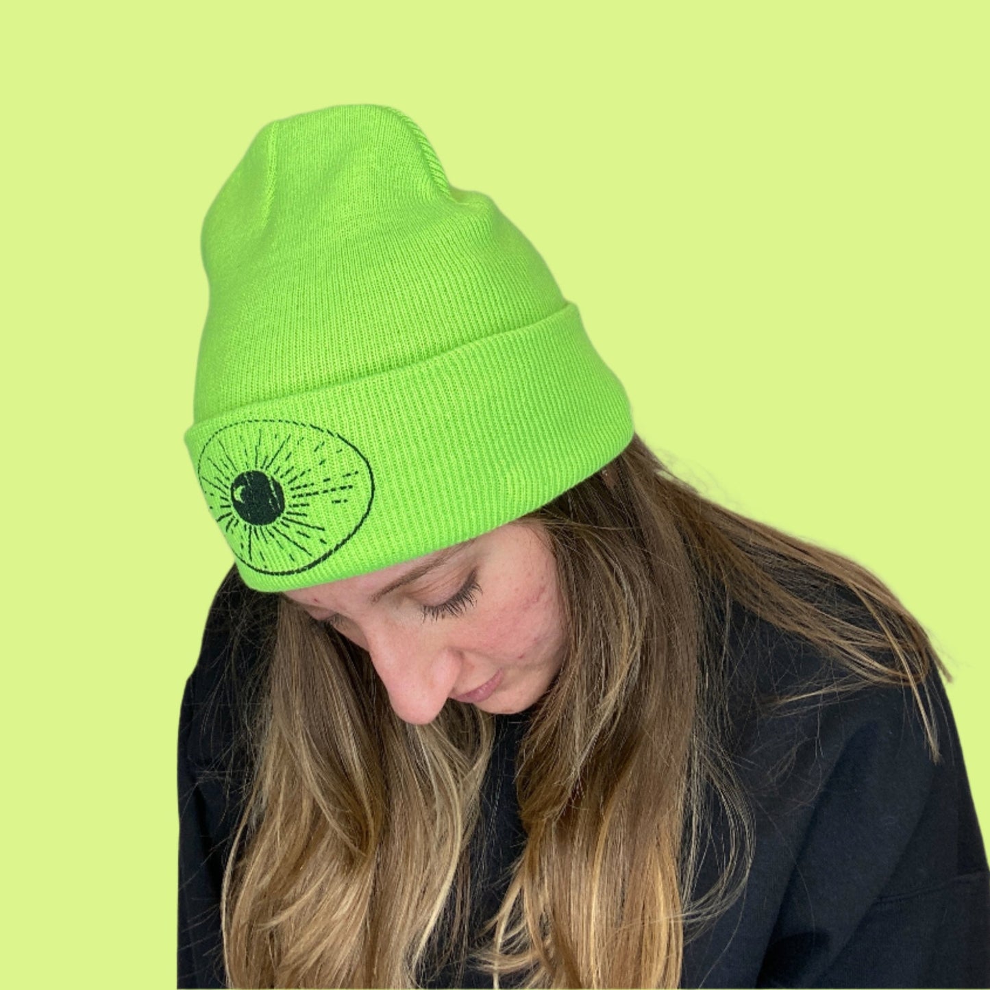 Lime Green Beanie with Night Sky Print on front fold being worn